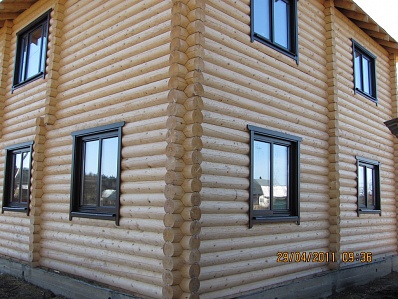 Деревянные окна с обсадой и наличниками в доме из оцилиндрованного бревна. Московская область